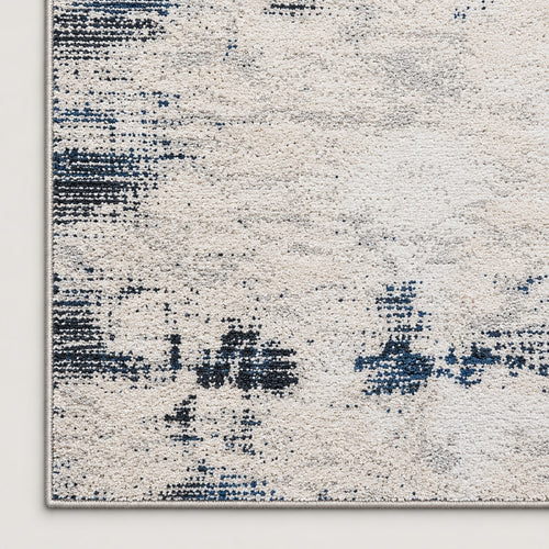 Tapis Brume ivoire et bleu nuit — coin et texture sur fond clair