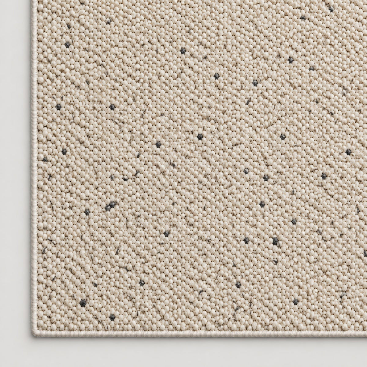 Tapis Galet beige moucheté — coin et texture sur fond clair